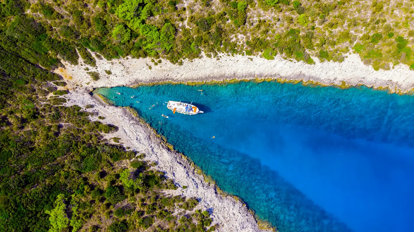 Aerial view of the boat in a narrow blue cove