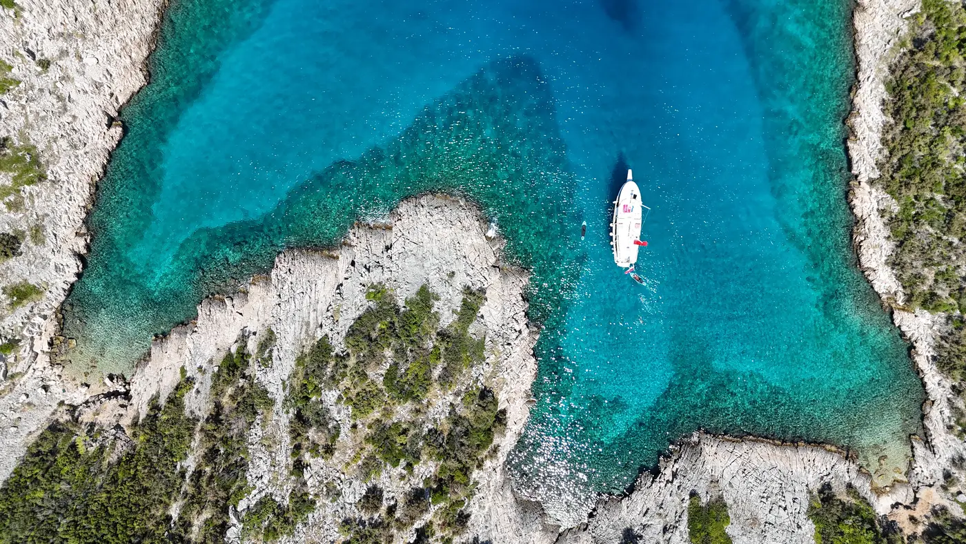 Aerial view of the boat in a turquoise cove