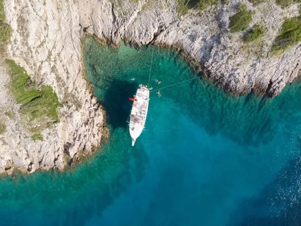 Aerial view of a white boat in a cove