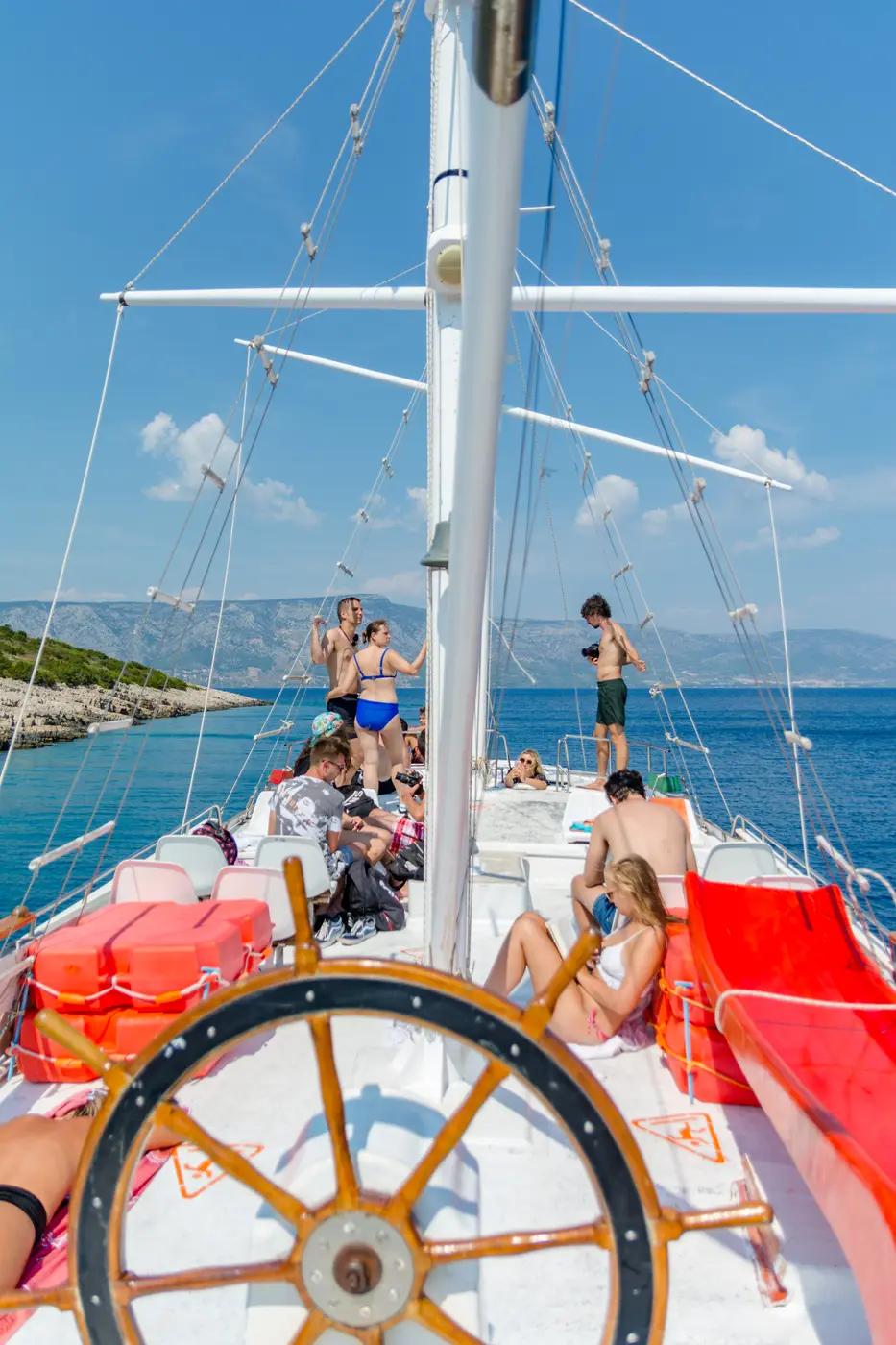 Passengers on deck by the ship’s wheel