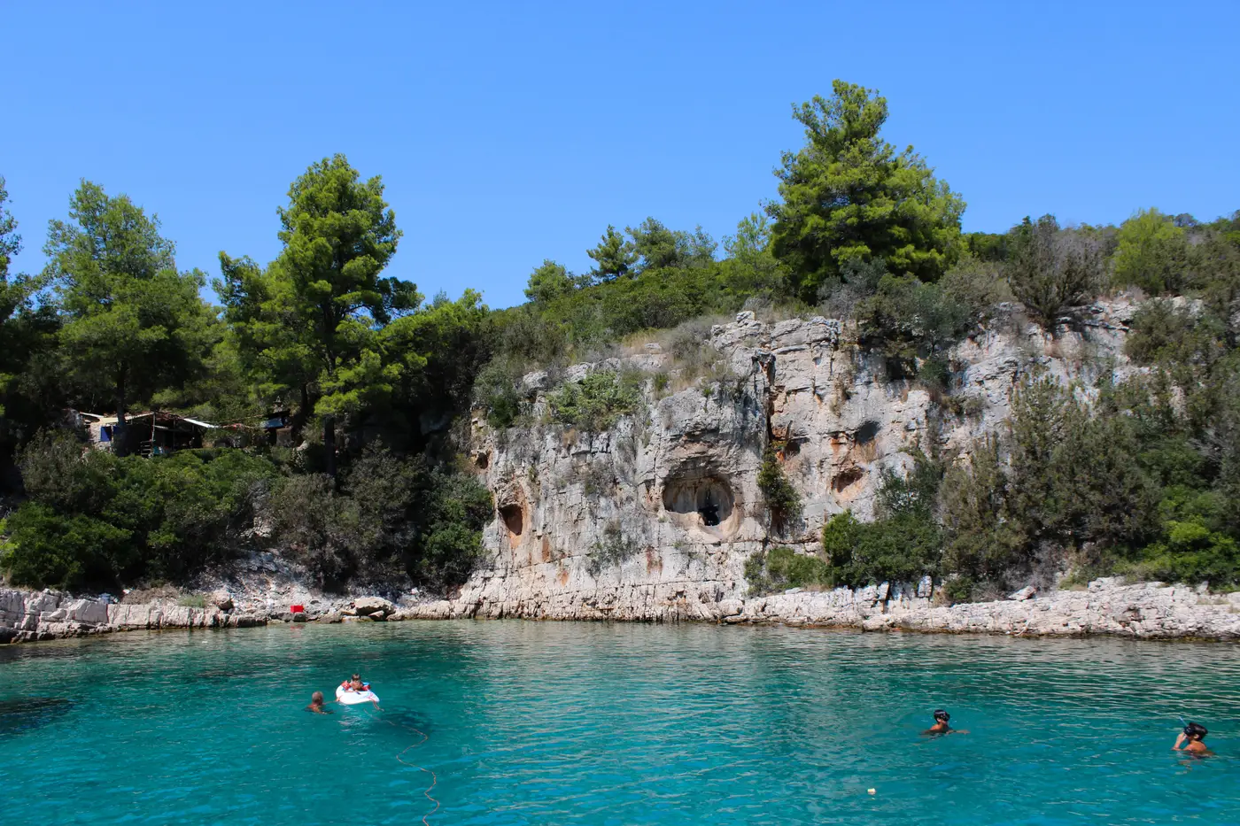 Swimmers by the rocky cove caves